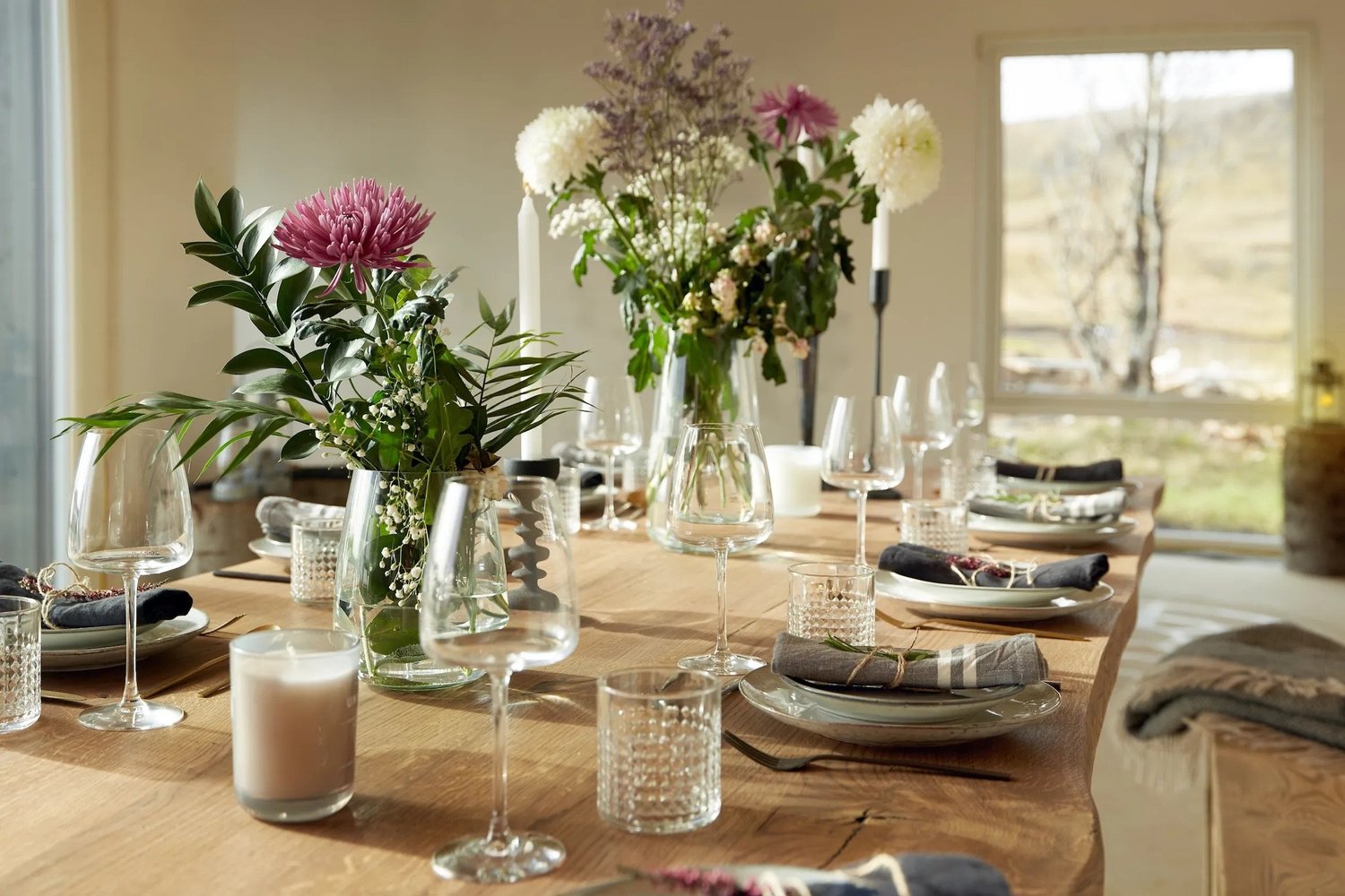 The lake-house dining table set with flowers and candles